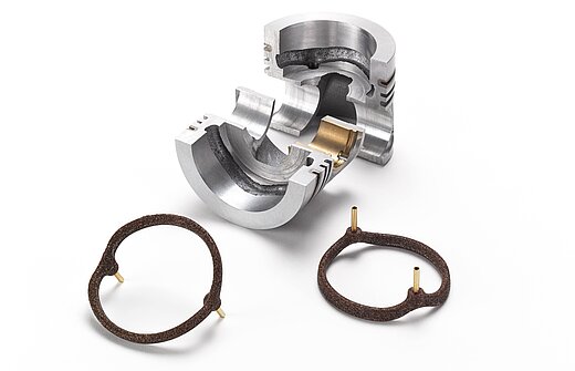 A silver piece of metal and brown salt cores for foundry technology