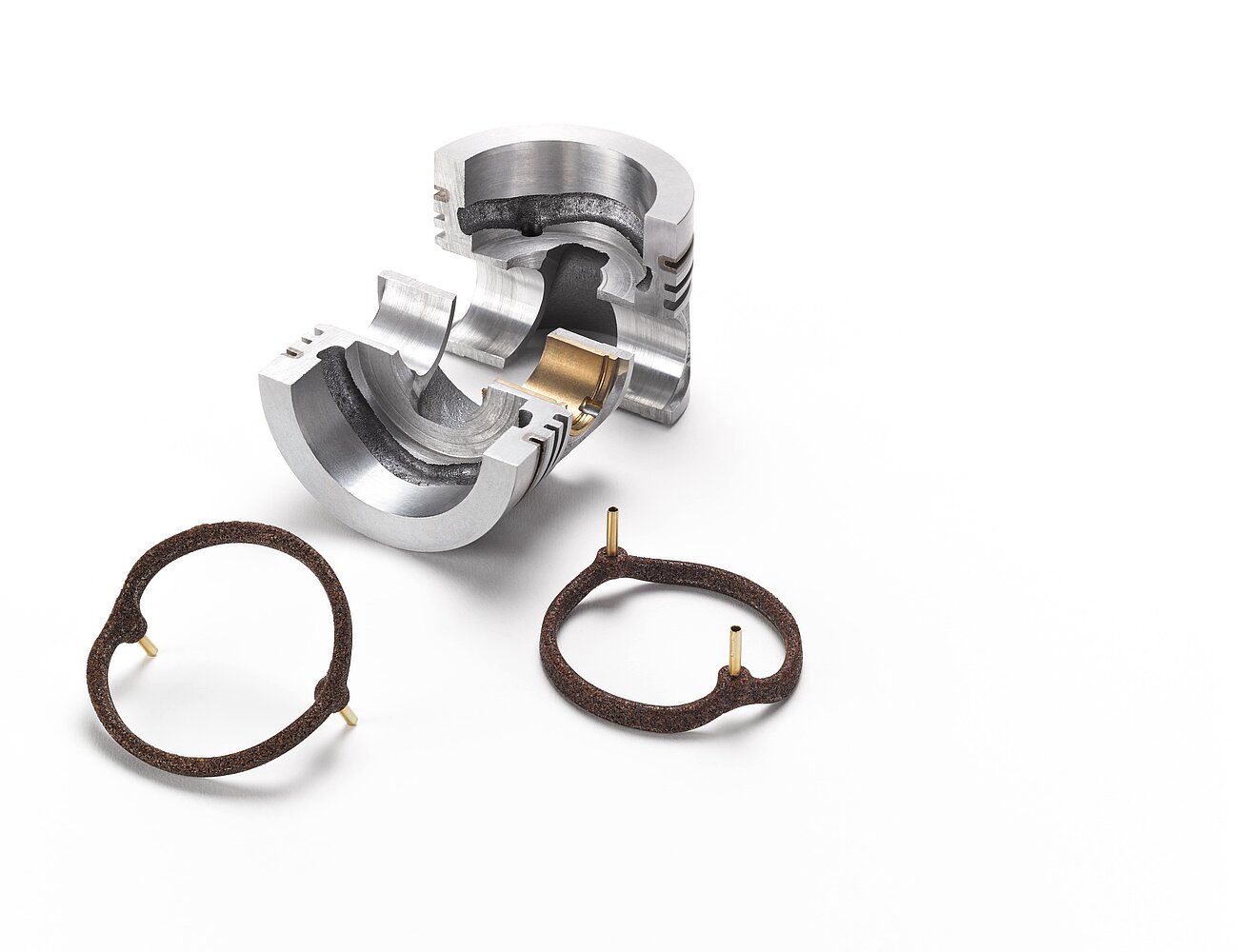 A silver piece of metal and brown salt cores for foundry technology