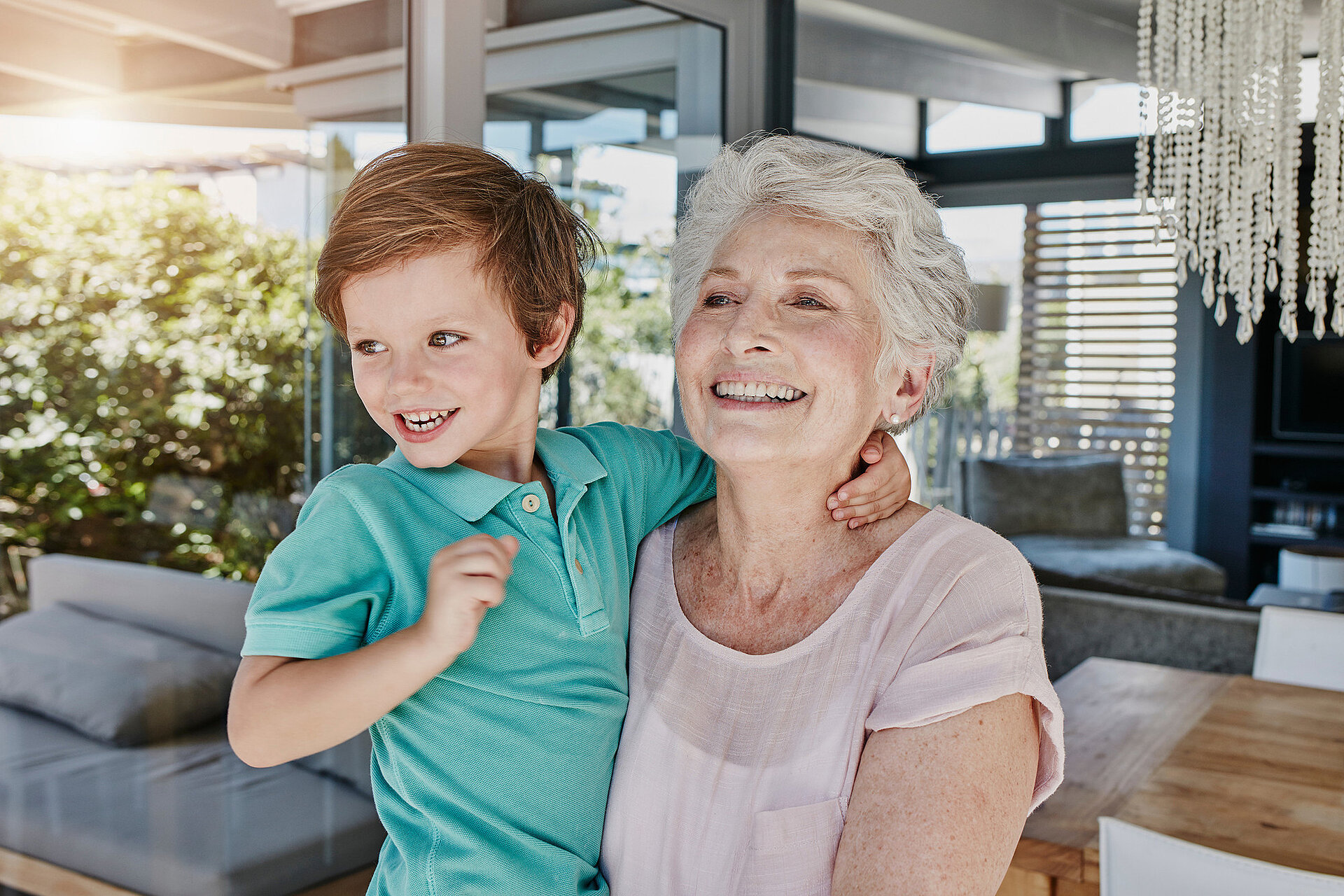 Une grand-mère tient son petit-fils dans ses bras, rayonnant de bonheur.