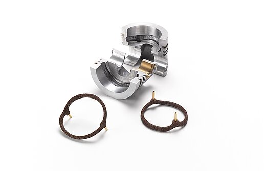A silver piece of metal and brown salt cores for foundry technology