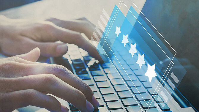 A hand is typing a five-star rating into a laptop