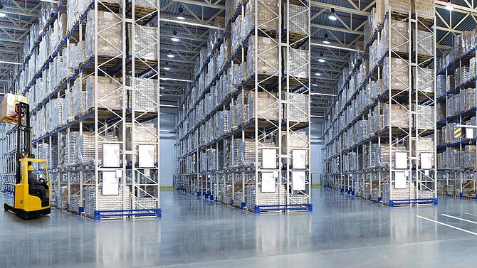 Huge distribution warehouse with high shelves and forklift