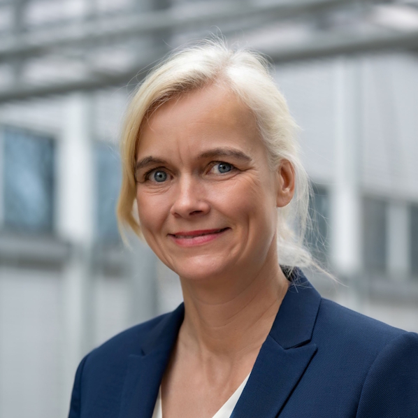 Dr Carla Kriwet looks into the camera. An industrial environment in the background